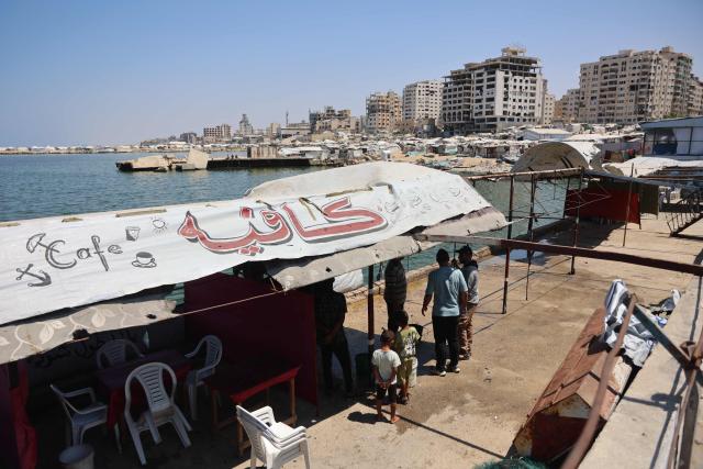 Palestinians stand at a site in Gaza City's port that was targeted by an Israeli army strike the previous day, on August 19, 2026. Gaza health officials said on August 18, 2026, that an Israeli airstrike killed six people in the port of Gaza City and wounded a dozen more, while the Israeli army said it had targeted several Hamas commanders. (Photo by Omar AL-QATTAA / AFP)
