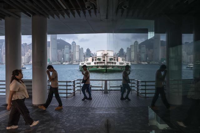 People walk next to Victoria harbour and the Star Ferry terminal in Hong Kong on August 19, 2026. (Photo by Dale DE LA REY / AFP)