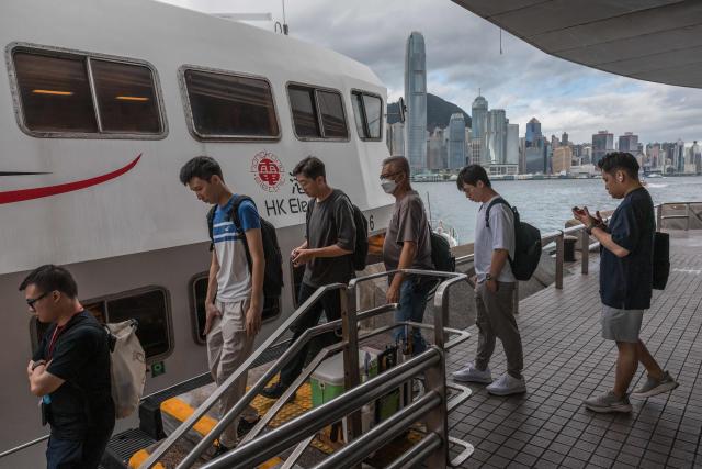 Workers board a HK Electric ferry at Victoria harbour in Hong Kong on August 19, 2026. (Photo by Dale DE LA REY / AFP)