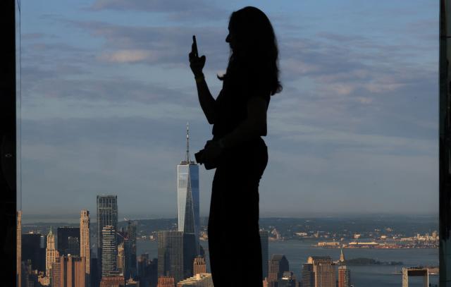 A person takes pictures as photographers, content creators, and visitors attend an event to celebrate World Photography Day at SUMMIT One Vanderbilt in New York City on August 19, 2026. (Photo by TIMOTHY A. CLARY / AFP)
