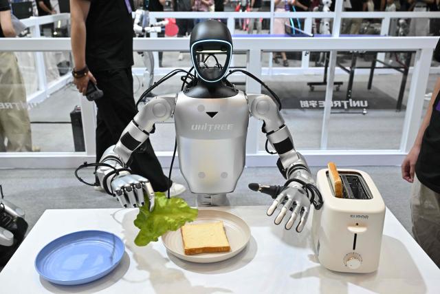 A Unitree humanoid robot prepares a sandwich during the 2026 World Robot conference in Beijing on August 19, 2026. (Photo by ADEK BERRY / AFP)