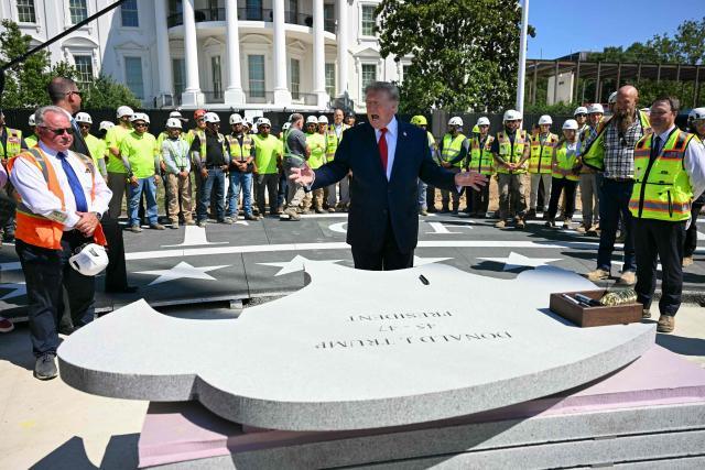 US President Donald Trump speaks before signing a piece of stone at the construction site of a helipad on the South Lawn of the White House in Washington, DC, on August 19, 2026. (Photo by Jim WATSON / AFP)