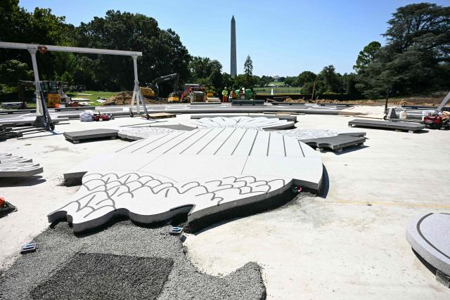 A view of construction site of a helipad, including an in progress stone presidential seal, as US President Donald Trump speaks to the press on the South Lawn of the White House in Washington, DC, on August 19, 2026. (Photo by Jim WATSON / AFP)