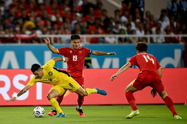 Vietnam's Nguyen Quang Hai (#19) vies for the ball with Malaysia’s Sergio Aguero (#8) during the second leg of the 2026 ASEAN Championship football semi-final match between Vietnam and Malaysia at My Dinh National Stadium in Hanoi on August 19, 2026. (Photo by Nhac NGUYEN / AFP)