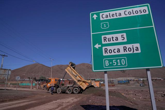 This image shows heavy machinery working at the Coloso fishermen's cove, affected by a mudslide following heavy rainfall in Antofagasta, northern Chile, on August 19, 2026. (Photo by SEBASTIAN ROJAS ROJO / AFP)