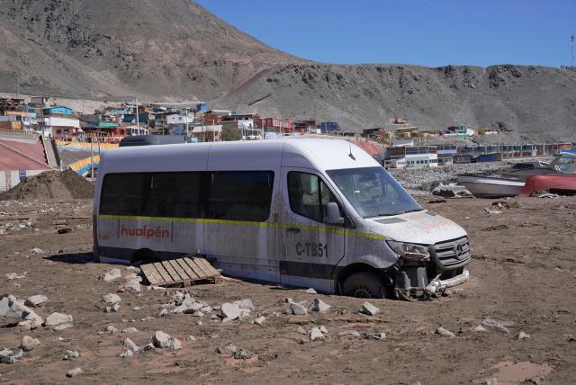 This image shows a van stranded at the Coloso fishermen's cove, affected by a mudslide following heavy rainfall in Antofagasta, northern Chile, on August 19, 2026. (Photo by SEBASTIAN ROJAS ROJO / AFP)