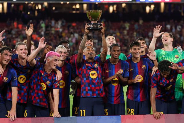 Barcelona's Brazilian forward #11 Raphinha (C) holds the trophy after Barcelona won the 61st Joan Gamper Trophy football match between FC Barcelona and Al Ahly FC at the Camp Nou Stadium in Barcelona on August 19, 2026. (Photo by Lluis GENE / AFP)