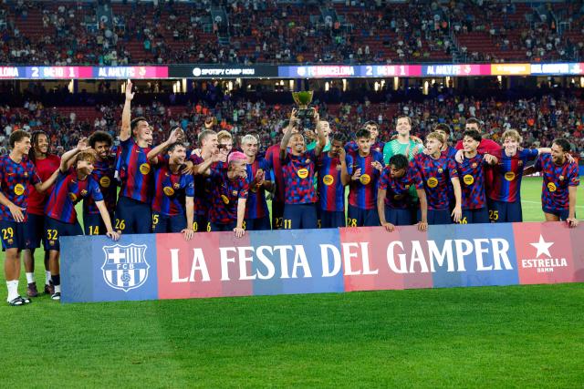 Barcelona's Brazilian forward #11 Raphinha (C) holds the trophy after Barcelona won the 61st Joan Gamper Trophy football match between FC Barcelona and Al Ahly FC at the Camp Nou Stadium in Barcelona on August 19, 2026. (Photo by Lluis GENE / AFP)