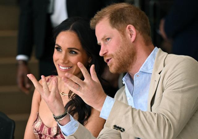 (FILES) Britain's Prince Harry (R), Duke of Sussex, speaks with his wife Meghan Markle while attending a show during a visit to the National Centre for the Arts in Bogota on August 15, 2024. Prince Harry and his wife Meghan, who cut ties with the British royal family in 2020, are moving back to the United Kingdom, British press reported on August 19, 2026. (Photo by RAUL ARBOLEDA / AFP)