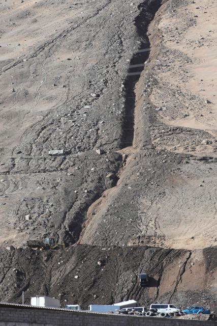 Damaged cars on the highway covered with mud and debris are pictured after a landslide struck the city of Iquique, due to heavy rainfall in the north of Chile on August 19, 2026. (Photo by Alex DIAZ / AFP)