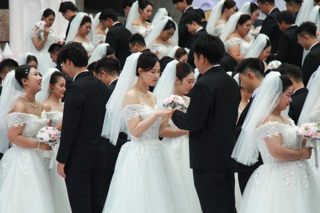 Couples take part in a collective wedding ceremony at the Hongmei Cultural and Creative Park in Shenyang, in northeastern China's Liaoning province, on August 19, 2026. (Photo by CN-STR / AFP) / China OUT