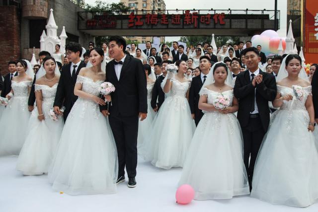 Couples take part in a collective wedding ceremony at the Hongmei Cultural and Creative Park in Shenyang, in northeastern China's Liaoning province, on August 19, 2026. (Photo by CN-STR / AFP) / China OUT