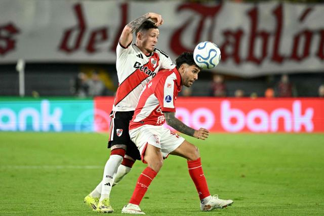River Plate's midfielder #6 Anibal Moreno and Santa Fe's Argentine forward #19 Nahuel Bustos fight for the ball during the first leg of the Copa Sudamericana round of 16 football match between Colombia's Independiente Santa Fe and Argentina's River Plate at the Nemesio Camacho 'El Campin' stadium, in Bogota, on August 19, 2026. (Photo by Luis ACOSTA / AFP)