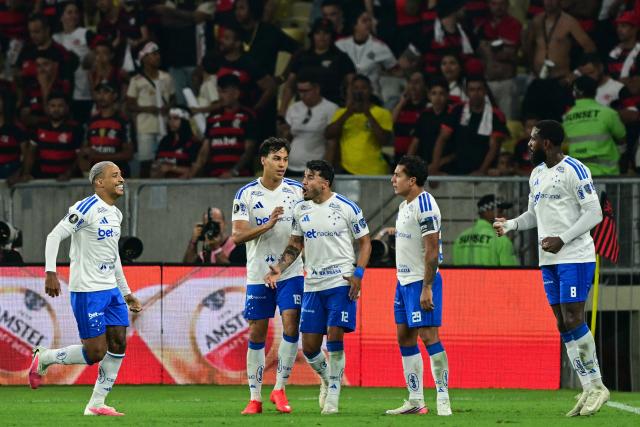 Cruzeiro's Paraguayan midfielder Lucas Romero (2nd-R) celebrates with teammates scoring his team's first goal during the second leg of the Copa Libertadores round of 16 football match between Brazilian teams Flamengo and Cruzeiro at the Maracana stadium in Rio de Janeiro, Brazil, on August 19, 2026. (Photo by Pablo PORCIUNCULA / AFP)