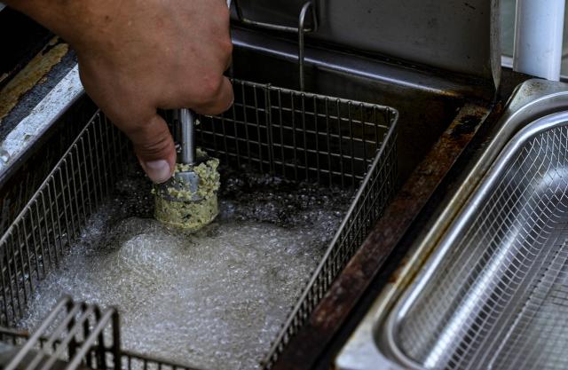 Palestinian Fadi Abed prepares falafel at his food stall "Hijo de Palestina", in La Plaza del Bolero in Tlalpan, on the outskirts of Mexico City, on August 14, 2026. Abed —one of 18 members of the Abed family, the first refugees to arrive in Mexico following Israeli bombardments of the Gaza Strip— launched a Palestinian food business which went viral and became highly popular thanks to the "Cumbia del Falafel"—a promotional jingle he plays as he drives his tricycle through the streets of Tlalpan and Mexico City. (Photo by Yuri CORTEZ / AFP)