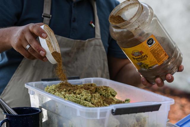 Palestinian Fadi Abed prepares falafel at his food stall "Hijo de Palestina", in La Plaza del Bolero in Tlalpan, on the outskirts of Mexico City, on August 14, 2026. Abed —one of 18 members of the Abed family, the first refugees to arrive in Mexico following Israeli bombardments of the Gaza Strip— launched a Palestinian food business which went viral and became highly popular thanks to the "Cumbia del Falafel"—a promotional jingle he plays as he drives his tricycle through the streets of Tlalpan and Mexico City. (Photo by Yuri CORTEZ / AFP)