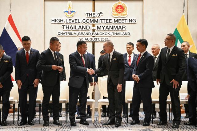 Myanmar’s military commander-in-chief, General Ye Win Oo (centre L) and Thailand’s Chief of Defence Forces, Ukrit Boontanon (centre R) shake hands after their High-Level Committee Meeting talks at the Chatrium Grand hotel in Bangkok on August 20, 2026. (Photo by ANTHONY WALLACE / AFP)