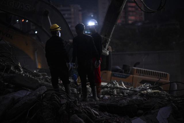 Rescue volunteers search through the rubble of collapsed buildings following the June 24 earthquakes along the coastal strip in Caraballeda, La Guaira state, Venezuela, on August 19, 2026. Nearly two months since the disaster, relatives and rescuers continue searching for the missing amid the rubble. The 7.2 and 7.5 magnitude quakes knocked down at least 190 buildings when they struck near Venezuela's coast on June 24. (Photo by Juan BARRETO / AFP)