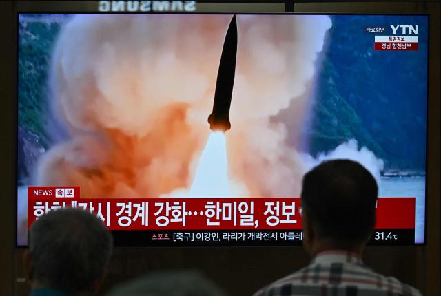 People watch a television screen showing a news broadcast with file footage of a North Korean missile test, at a train station in Seoul on August 20, 2026. North Korea fired around 10 short-range ballistic missiles, South Korea's military said on August 20, hours after US President Donald Trump said he would meet Pyongyang's leader Kim Jong Un later this year. (Photo by Jung Yeon-je / AFP)
