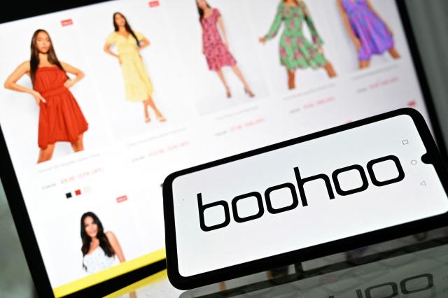 (FILES) An illustration with a mobile phone and laptop shows the logo and website of online fashion group Boohoo on August 12, 2021. The British online clothing retailer Boohoo has been fined Ђ2.33 million following an investigation that uncovered "misleading commercial practices," France’s consumer fraud watchdog announced on August 20, 2026. (Photo by JUSTIN TALLIS / AFP)