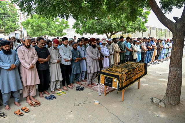 Relatives and residents pray next to the coffin of Muhammad Akram, a vessel's crew member who got killed in an attack by the Houthi rebels in the Red Sea, during a funeral ceremony in Karachi on August 20, 2026. (Photo by Rizwan TABASSUM / AFP)