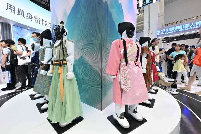 Humanoid robots produced by Noetix dressed in Chinese traditional outfits are pictured during the 2026 World Robot Conference in Beijing on August 20, 2026. (Photo by ADEK BERRY / AFP)