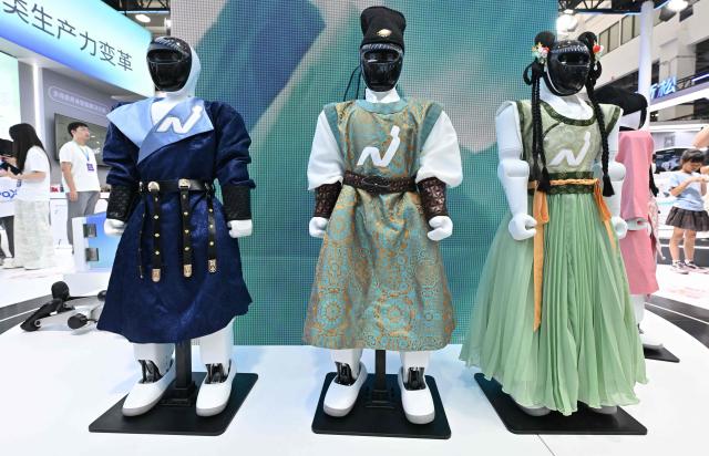 Humanoid robots produced by Noetix dressed in Chinese traditional outfits are pictured during the 2026 World Robot Conference in Beijing on August 20, 2026. (Photo by ADEK BERRY / AFP)