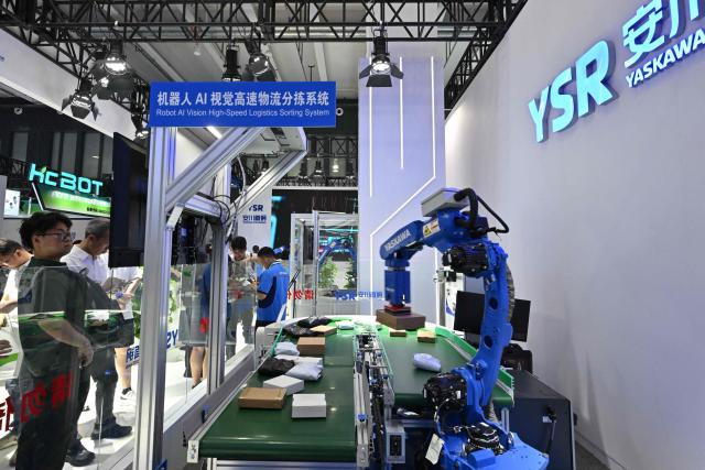 People visit the stand of a joint venture Japan-China company Yaskawa Shougang Robot Co., Ltd (YSR) during the 2026 World Robot Conference in Beijing on August 20, 2026. (Photo by ADEK BERRY / AFP)