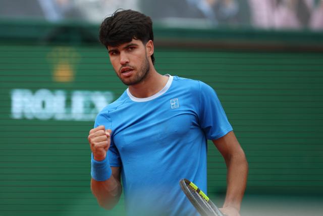 (FILES) Spain's Carlos Alcaraz reacts as he plays against Italy's Jannik Sinner during the Monte Carlo ATP Masters Series Tournament final tennis match on Court Rainier III at the Monte-Carlo Country Club in Roquebrune-Cap-Martin, south-eastern France on April 12, 2026. Carlos Alcaraz announced on August 20, 2026 that he will return at the US Open to defend his title after recovering from a wrist injury that has sidelined him for the past four months. (Photo by Valery HACHE / AFP)