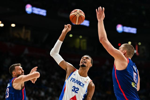France's #32 Victor Wembanyama (C) fights for the ball against Serbia's #23 Marko Guduric (L) and Serbia's #15 Nikola Jokic (R) during the friendly basketball match between Serbia and France, at the Belgrade Arena, in Belgrade, on August 20, 2026. (Photo by Andrej ISAKOVIC / AFP)