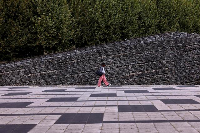 A woman walks across the forecourt of Grenoble University in Saint-Martin-d'Heres, southeastern France on August 20, 2026. (Photo by Alex MARTIN / AFP)