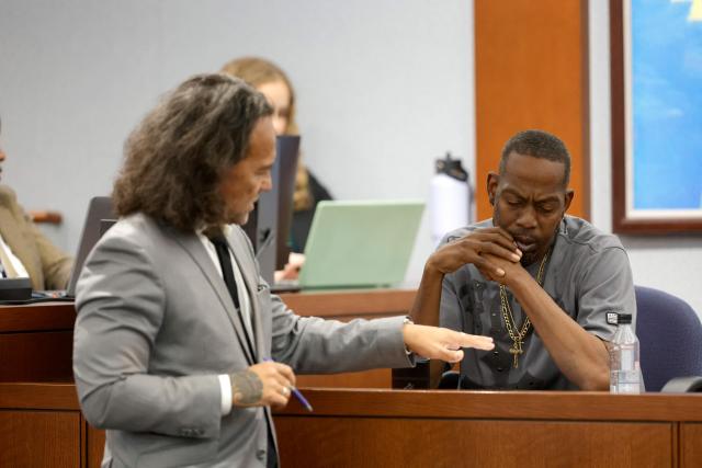 Michael Sanft (L), attorney for Duane Davis, shows a document to Denvonta Lee, an affiliate of the gang alliance South Side Compton Crips, as he testifies during Duane Davis's murder trial, related to the 1996 killing of rapper Tupac Shakur, at Clark County District Court at the Regional Justice Center in Las Vegas, Nevada, on August 20, 2026. The trial of the former gang leader accused of orchestrating the murder of rapper Tupac Shakur began on August 10, 30 years after one of America's most high-profile unresolved killings. The proceedings, expected to last a month, will likely not make clear who fired the shots that killed the California hip-hop legend on the night of September 7, 1996, while he was in Las Vegas to see a Mike Tyson boxing match. (Photo by Steve Marcus / POOL / AFP)