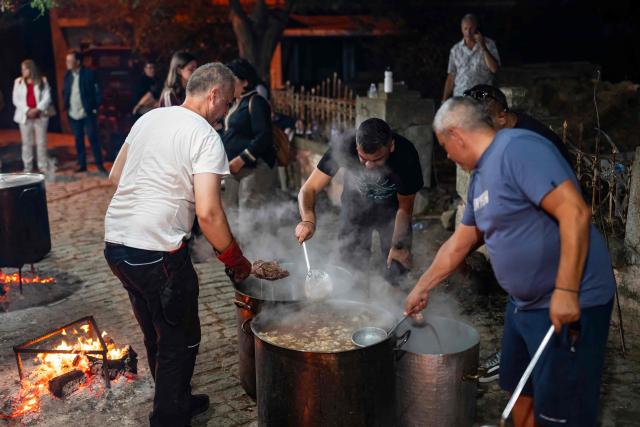 Men cook some meat in large cauldrons for the Feast of the Dormition of the Virgin Mary near the Evangelismos Teotoku church on Gokceada (Imroz) Island, Çanakkale Province of Turkey, on August 14, 2026. Hundreds of Greeks return from Athens and around the world to Imbros each August 15 to celebrate the Virgin Mary. Like Istanbul and nearby Tenedos, the island was exempt from the 1923 population exchange between Greece and Turkey, which displaced more than 1.5 million people. (Photo by Yasin AKGUL / AFP)