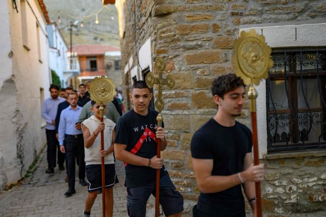 Worshippers attend Feast of the Dormition of the Virgin Mary at the Evangelismos Teotoku church on Gokceada (Imroz) Island, Çanakkale Province, on August 14, 2026. Hundreds of Greeks return from Athens and around the world to Imbros each August 15 to celebrate the Virgin Mary. Like Istanbul and nearby Tenedos, the island was exempt from the 1923 population exchange between Greece and Turkey, which displaced more than 1.5 million people. (Photo by Yasin AKGUL / AFP)