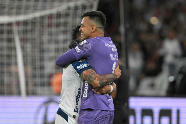 Liga de Quito's goalkeeper #1 Gonzalo Valle celebrates with a teammate after winning the penalty shootout of the second leg of the Copa Libertadores round of 16 football match between Ecuador's Liga de Quito and Brazil's Mirassol at the Rodrigo Paz Delgado stadium in Quito, on August 20, 2026. (Photo by Rodrigo BUENDIA / AFP)