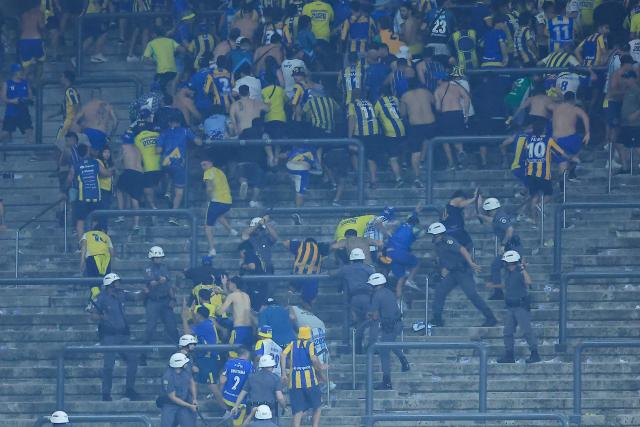 Rosario Central's fans Rosario Central’s fans clash with police at the end of the Copa Libertadores round of 16 football match between Brazil's Corinthians and Argentina's Rosario Central at the Neo Quimica Arena stadium in Sao Paulo, Brazil, on August 20, 2026. (Photo by Miguel SCHINCARIOL / AFP)