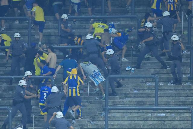 Rosario Central's fans Rosario Central’s fans clash with police at the end of the Copa Libertadores round of 16 football match between Brazil's Corinthians and Argentina's Rosario Central at the Neo Quimica Arena stadium in Sao Paulo, Brazil, on August 20, 2026. (Photo by Miguel SCHINCARIOL / AFP)