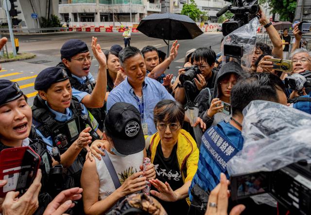 Lau Ka-yee (C), former Hong Kong Alliance standing committee member, and Medina Chow Lau Wah-chun (centre L), Chow Hang-tung's mother, leave the West Kowloon Magistrates' Courts after the verdict in the national security trial of two pro-democracy Tiananmen activists, in Hong Kong on August 21, 2026. A Hong Kong court found two pro-democracy activists who organised annual vigils to mark China's deadly Tiananmen crackdown guilty of "incitement to subversion" on August 21. (Photo by Leung Man Hei / AFP)