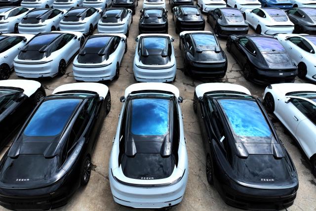 China-made Zeekr cars awaiting shipment to Singapore are loaded onto the 'Anji Ansheng' vessel at Dongfang Port Company terminal in Lianyungang, in eastern China's Jiangsu province on August 21, 2026. (Photo by CN-STR / AFP) / China OUT