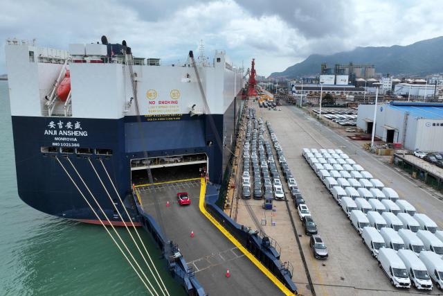 Vehicles for export to Singapore are loaded onto the 'Anji Ansheng' vessel at Dongfang Port Company terminal in Lianyungang, in eastern China's Jiangsu province on August 21, 2026. (Photo by CN-STR / AFP) / China OUT