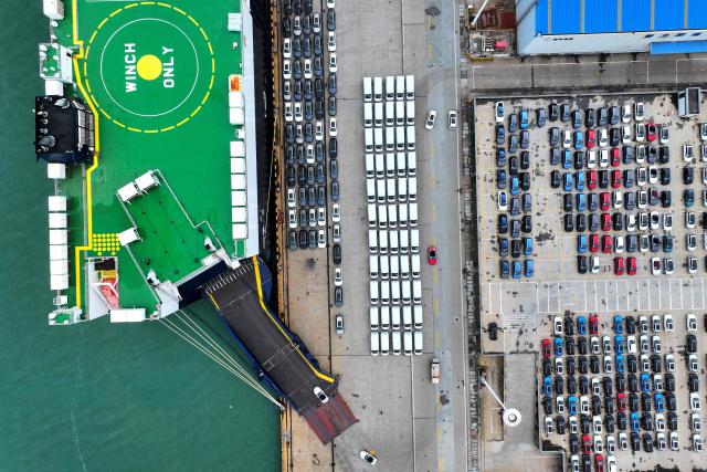 An aerial view shows vehicles for export to Singapore being loaded onto the 'Anji Ansheng' vessel at Dongfang Port Company terminal in Lianyungang, in eastern China's Jiangsu province on August 21, 2026. (Photo by CN-STR / AFP) / China OUT