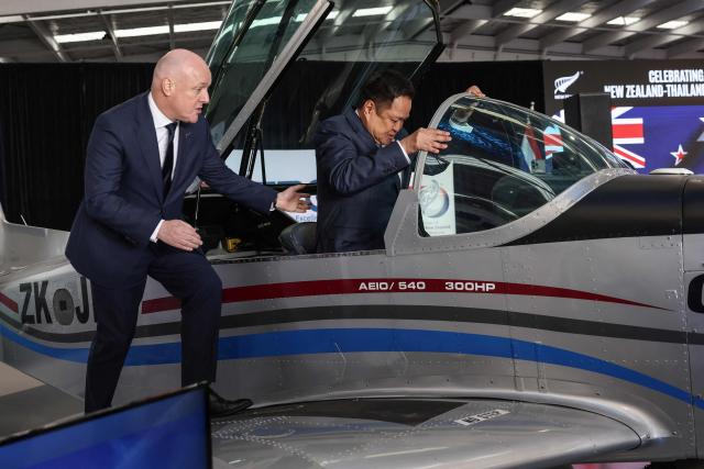 Thailand's Prime Minister Anutin Charnvirakul (C) and New Zealand's Prime Minister Christopher Luxon (L) hope into a CT/4E plane during a visit to aircraft manufacturing company 'NZ Aero' in Auckland on August 21, 2026. (Photo by Michael Bradley / AFP)