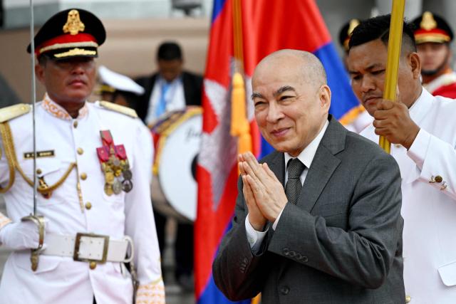 Cambodia's King Norodom Sihamoni gestures as he walks past honour guards after the inauguration ceremony of the new Senate building, known as Solidarity Palace, in Phnom Penh on August 21, 2026. (Photo by TANG CHHIN Sothy / AFP)