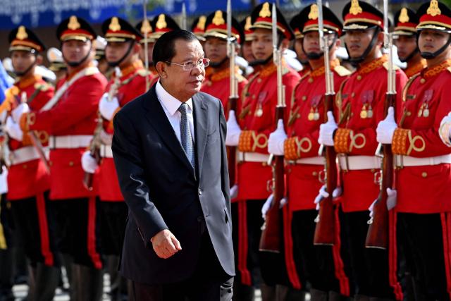 Cambodian Senate President Hun Sen walks past honour guards during the inauguration ceremony of the new Senate building, known as Solidarity Palace, in Phnom Penh on August 21, 2026. (Photo by TANG CHHIN Sothy / AFP)
