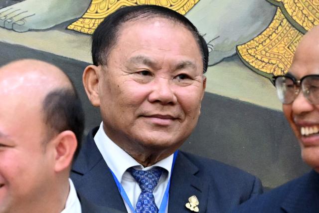 Tycoon Ly Yong Phat (C) looks on as he prepares to pose for a picture with King Norodom Sihamoni, Senators and government officials during the inauguration ceremony of the new Senate building, known as Solidarity Palace, in Phnom Penh on August 21, 2026. (Photo by TANG CHHIN Sothy / AFP)