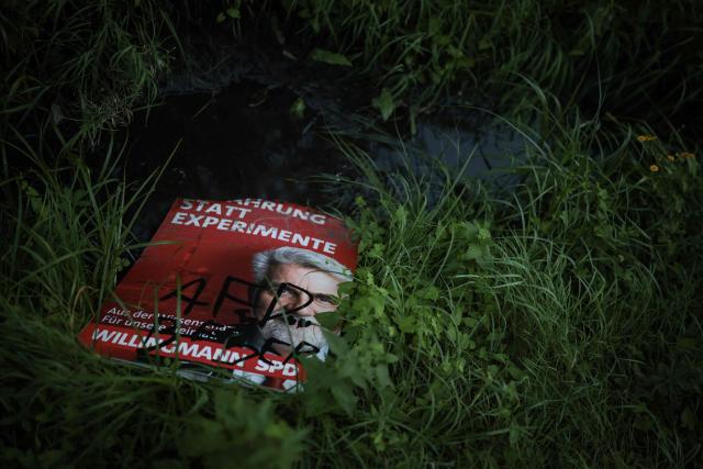 An election poster for the Social Democratic Party's (SPD) main candidate in the Saxony-Anhalt state election Armin Willingmann, damaged with a graffiti that reads "AfD is better" lies in the grass in Magdeburg, eastern Germany, on August 20, 2026. Regional elections in the eastern federal state of Saxony-Anhalt will take place on September 6, 2026. (Photo by Ronny HARTMANN / AFP)
