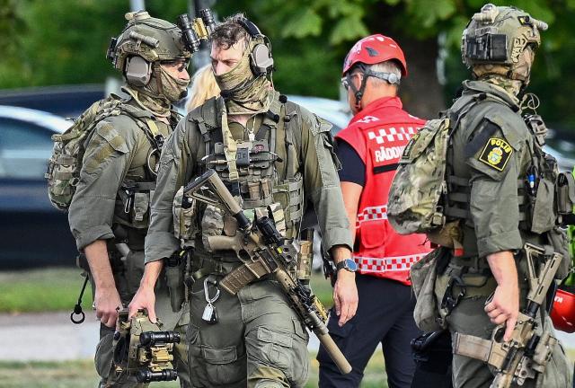 Police special forces work at the scene where an attacker with a sword wounded several people at a high school in Fagersta, central Sweden on August 21, 2026. At least three were wounded after an attacker with a sword entered a high school in central Sweden, authorities said, while media reported the perpetrator had been shot by police. "An assailant armed with a sword has entered Brinellskolan and wounded several people," the Fagersta municipality said in a statement, adding the assailant had been detained by police. Aftonbladet newspaper reported that a person wielding a machete had been shot by police. (Photo by Fredrik SANDBERG / TT NEWS AGENCY / AFP) / Sweden OUT
