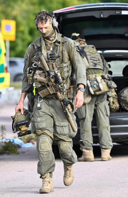 Police special forces work at the scene where an attacker with a sword wounded several people at a high school in Fagersta, central Sweden on August 21, 2026. At least three were wounded after an attacker with a sword entered a high school in central Sweden, authorities said, while media reported the perpetrator had been shot by police. "An assailant armed with a sword has entered Brinellskolan and wounded several people," the Fagersta municipality said in a statement, adding the assailant had been detained by police. Aftonbladet newspaper reported that a person wielding a machete had been shot by police. (Photo by Fredrik SANDBERG / TT NEWS AGENCY / AFP) / Sweden OUT
