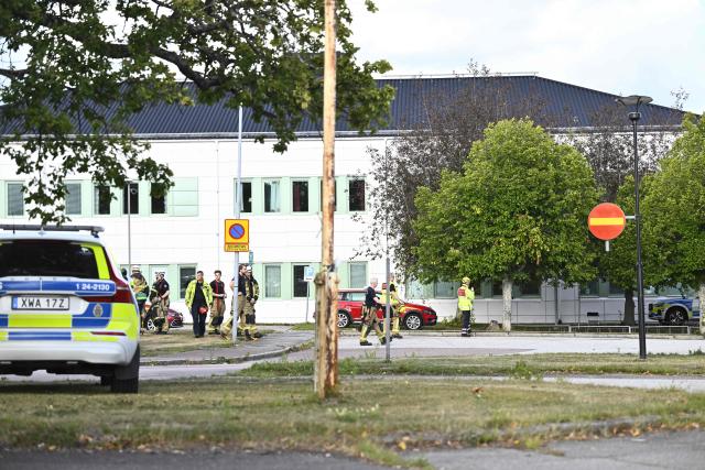 Members of the emergency services work at the scene where an attacker with a sword wounded several people at a high school in Fagersta, central Sweden on August 21, 2026. At least three were wounded after an attacker with a sword entered a high school in central Sweden, authorities said, while media reported the perpetrator had been shot by police. "An assailant armed with a sword has entered Brinellskolan and wounded several people," the Fagersta municipality said in a statement, adding the assailant had been detained by police. Aftonbladet newspaper reported that a person wielding a machete had been shot by police. (Photo by Fredrik SANDBERG / TT NEWS AGENCY / AFP) / Sweden OUT
