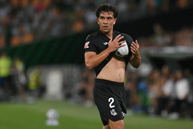 Real Sociedad's Venezuelan defender #02 Jon Aramburu holds the ball in his jersey during the Spanish league football match between Real Betis and Real Sociedad at the Cartuja stadium in Seville on August 21, 2026. (Photo by JORGE GUERRERO / AFP)